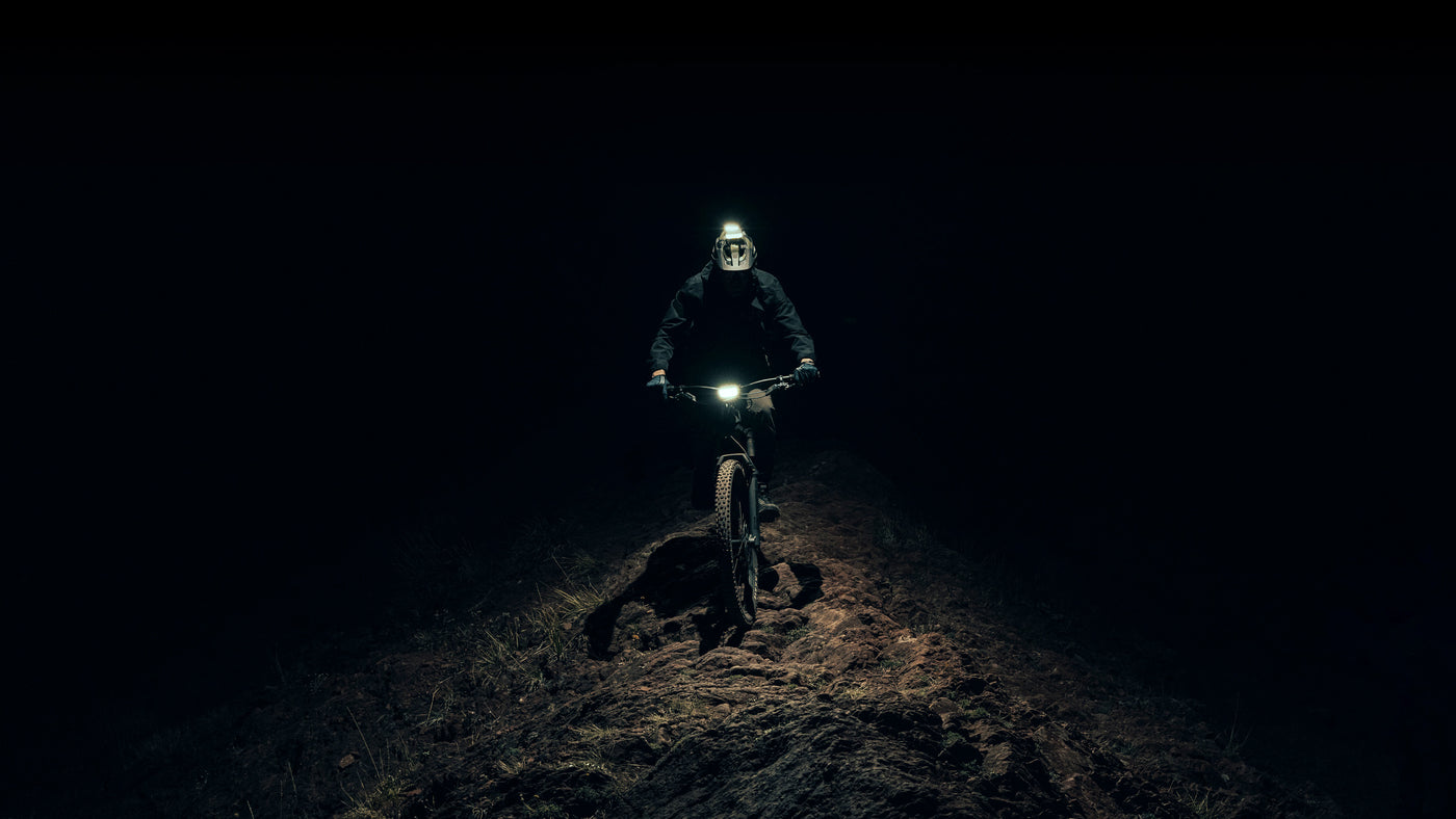 Bike rider on utah ridge at night with two bike lights