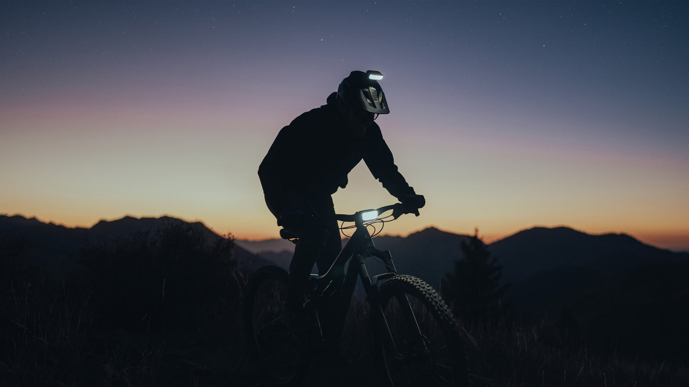 bike rider at sunset in the mountains while wearing two bike lights