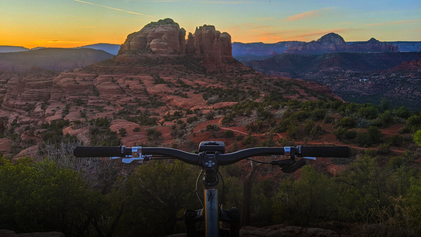 Bike rider at sunset on top of the mountains with Trail Evo on the handlebar