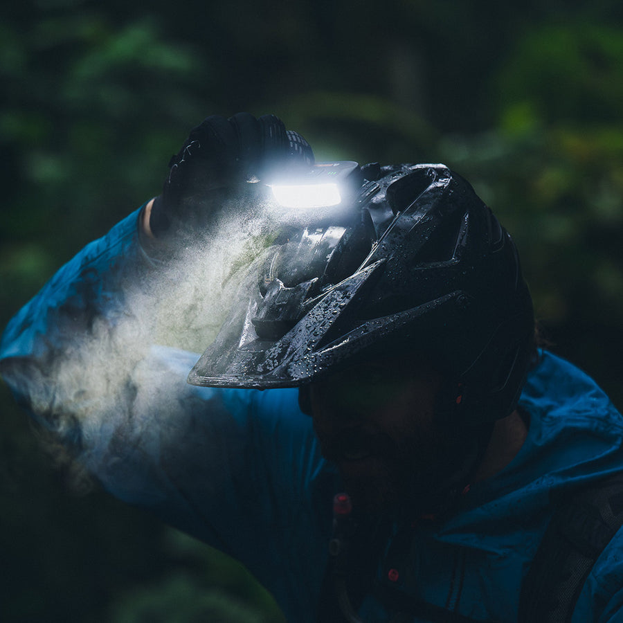 Portal helmet light shining through dust and wet trail conditions