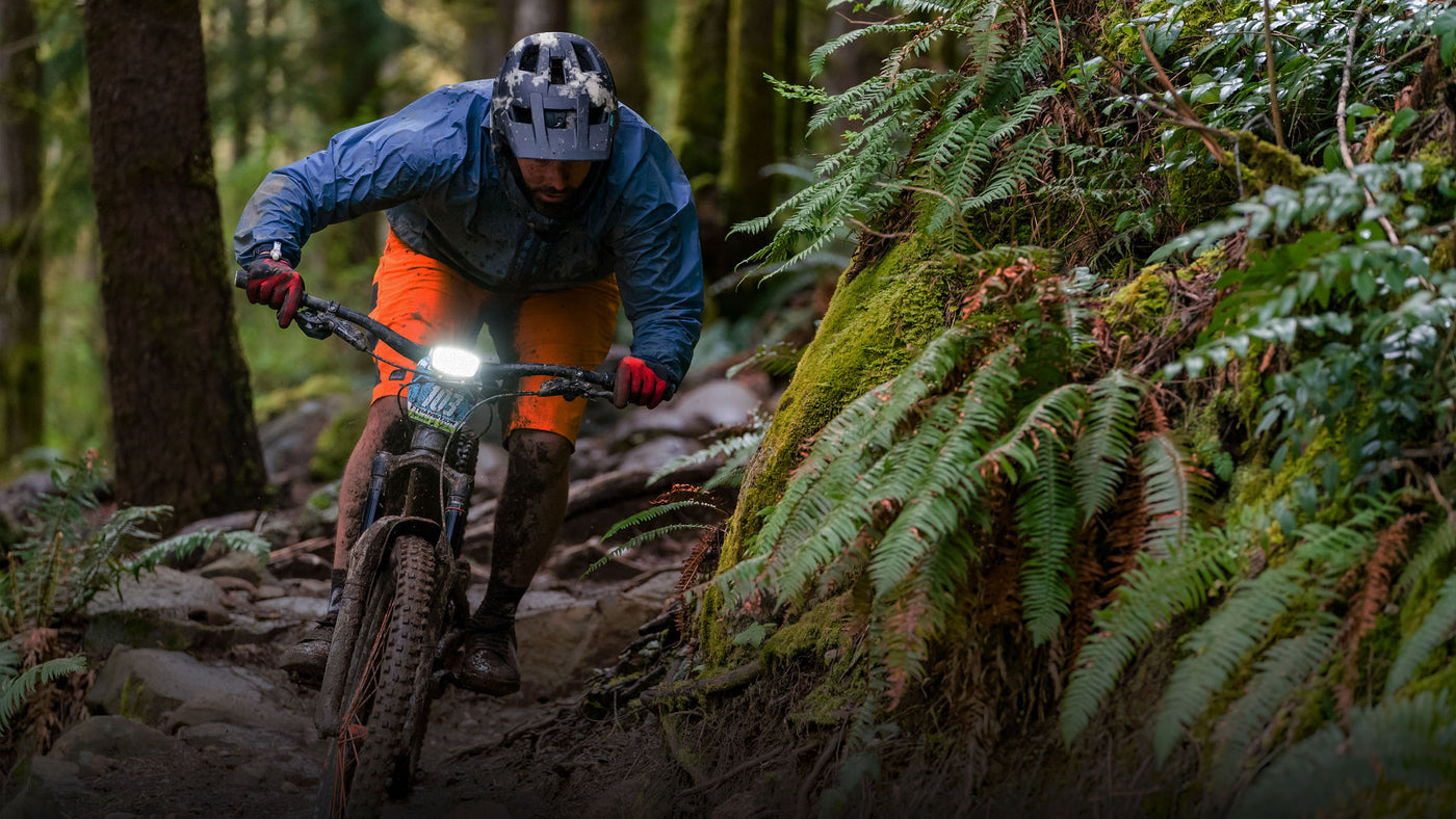 bike racer in a wet PNW forest with Trail Evo on the handlebar