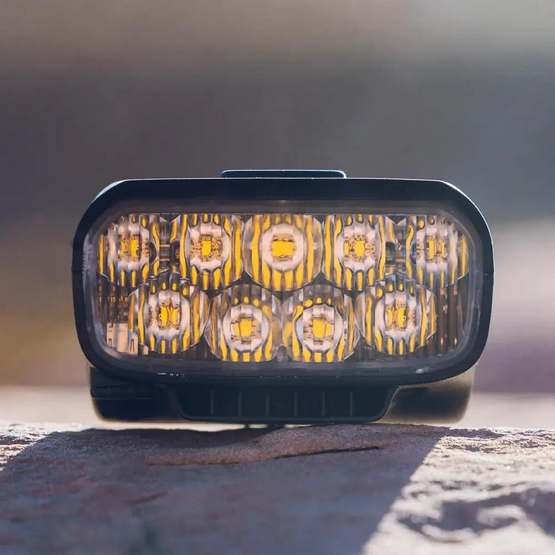 Trail Evo mountain bike light sitting on a rock, front view of the LED optics